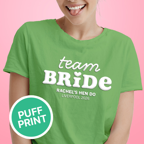 A female model wearing a green hen do shirt with custom white 'puff print' bubble writing that reads Team Bride, Rachel's Hen Do, Liverpool 2026 