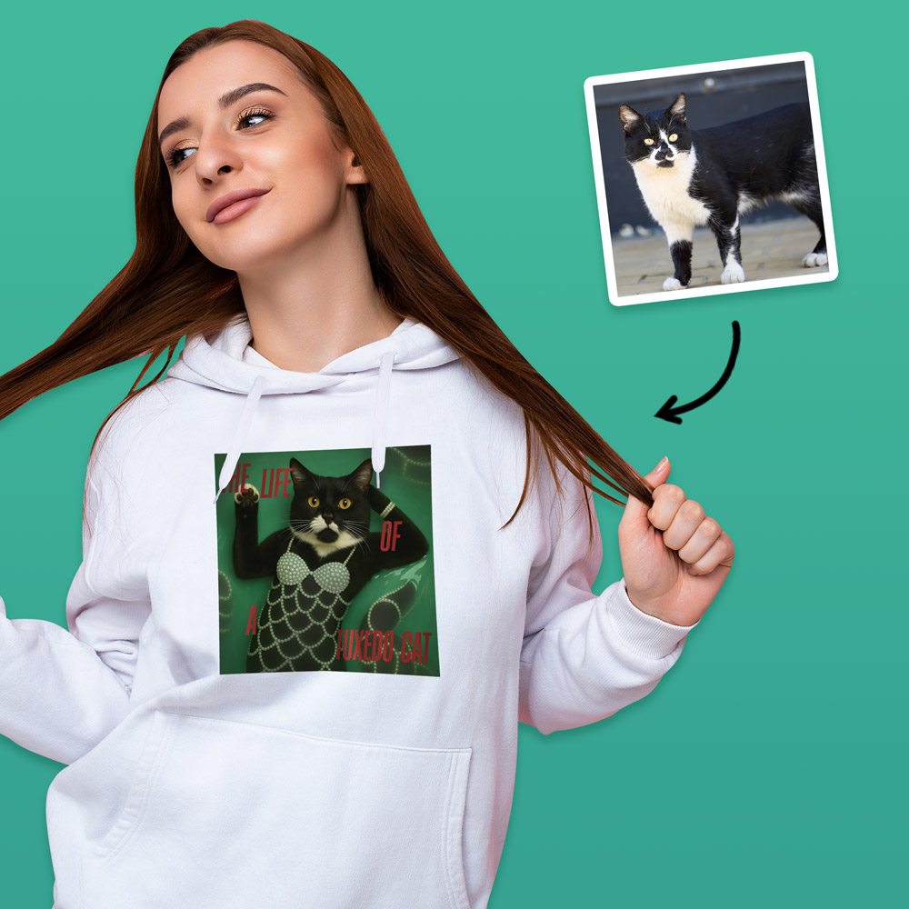 A female model wearing aTaylor Swift inspired hoodie that can have a photo of your pet added to it so it looks like they are a part of the Life of a Showgirl album, which has a cat on it with the text life of a tuxedo cat