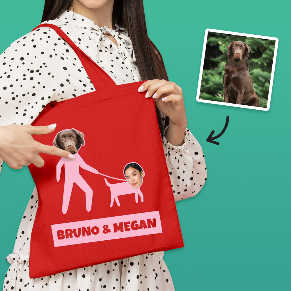 A red tote bag that can be customised with the face of a pet and its owner, this one makes it look like the owner is walking the dog with custom text reading Bruno & Megan