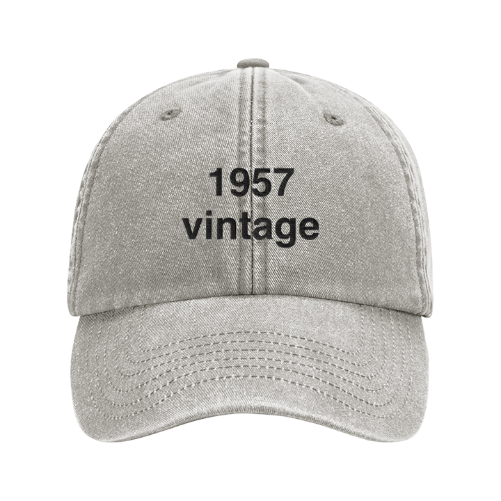 A premium vintage birthday cap in sand with the custom text 1957 vintage embroidered on it in black font 