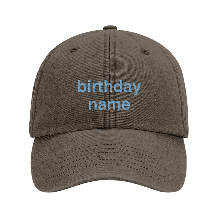A premium hen do cap in blue that has been embroidered with the phrase bikinis and martinis in a pink font 