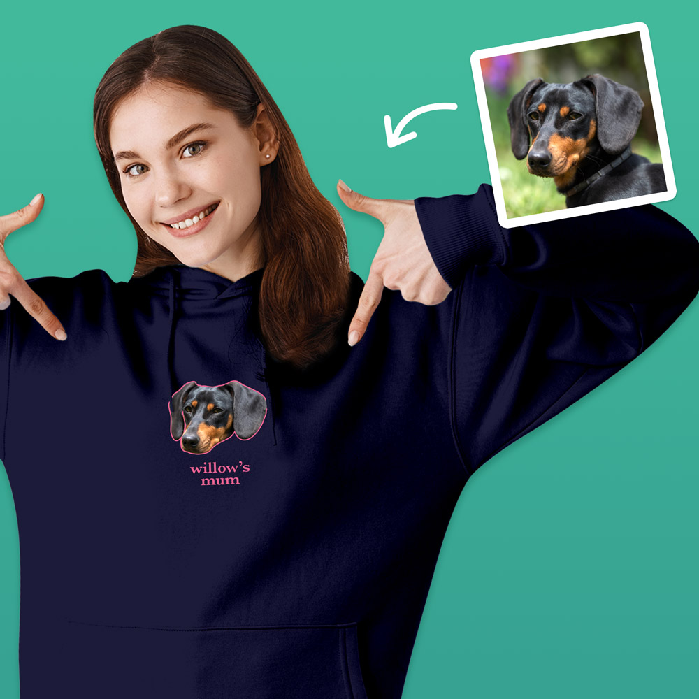 A female model wearing a dark blue hoodie that can be customised with the face of a pet and up to two lines of custom text which has a dog's face on it with the word willow under it