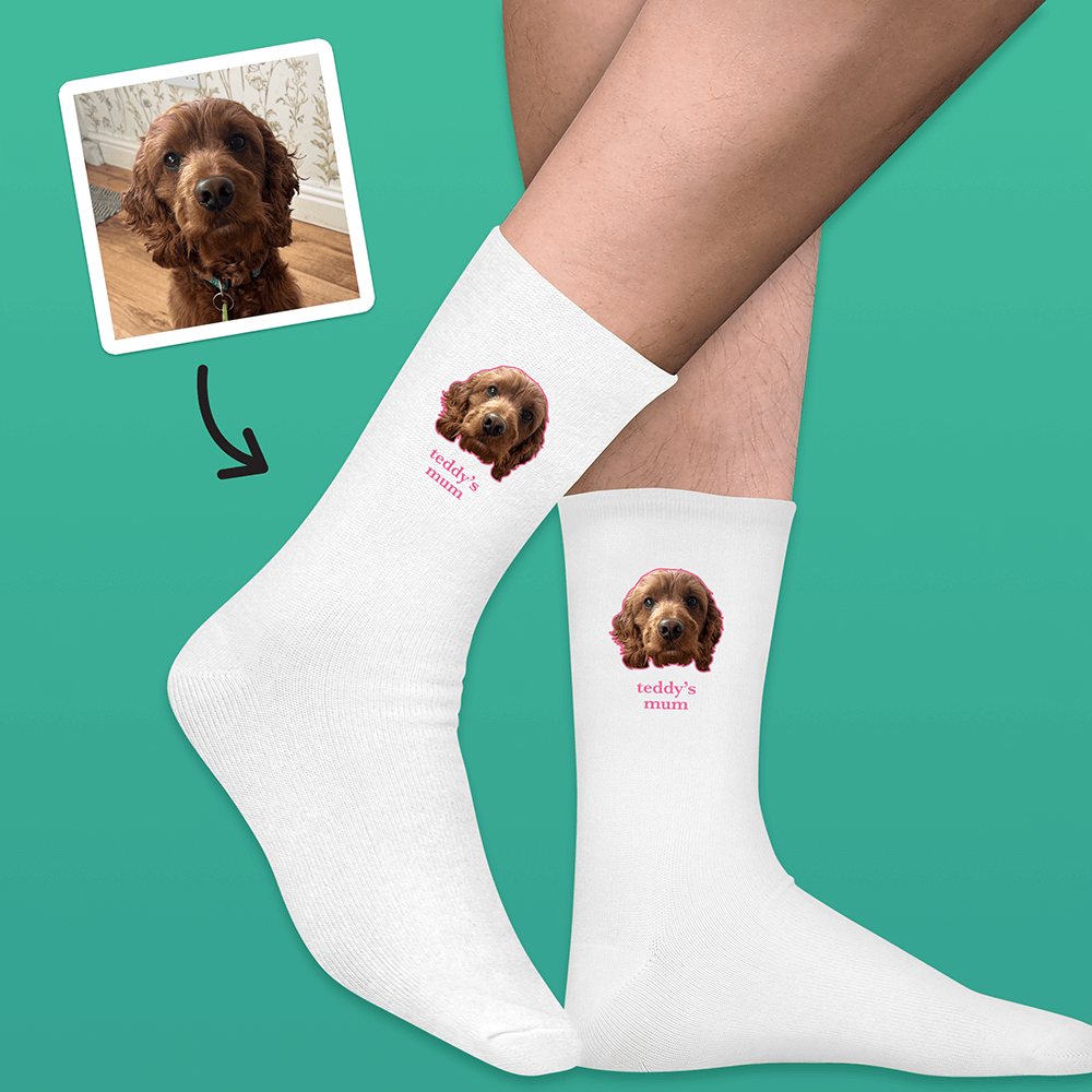 A pair of white socks that can be customised with the face of a pet and up to two lines of custom text that have a picture of a dog on each sock with the words teddy's mum underneath it