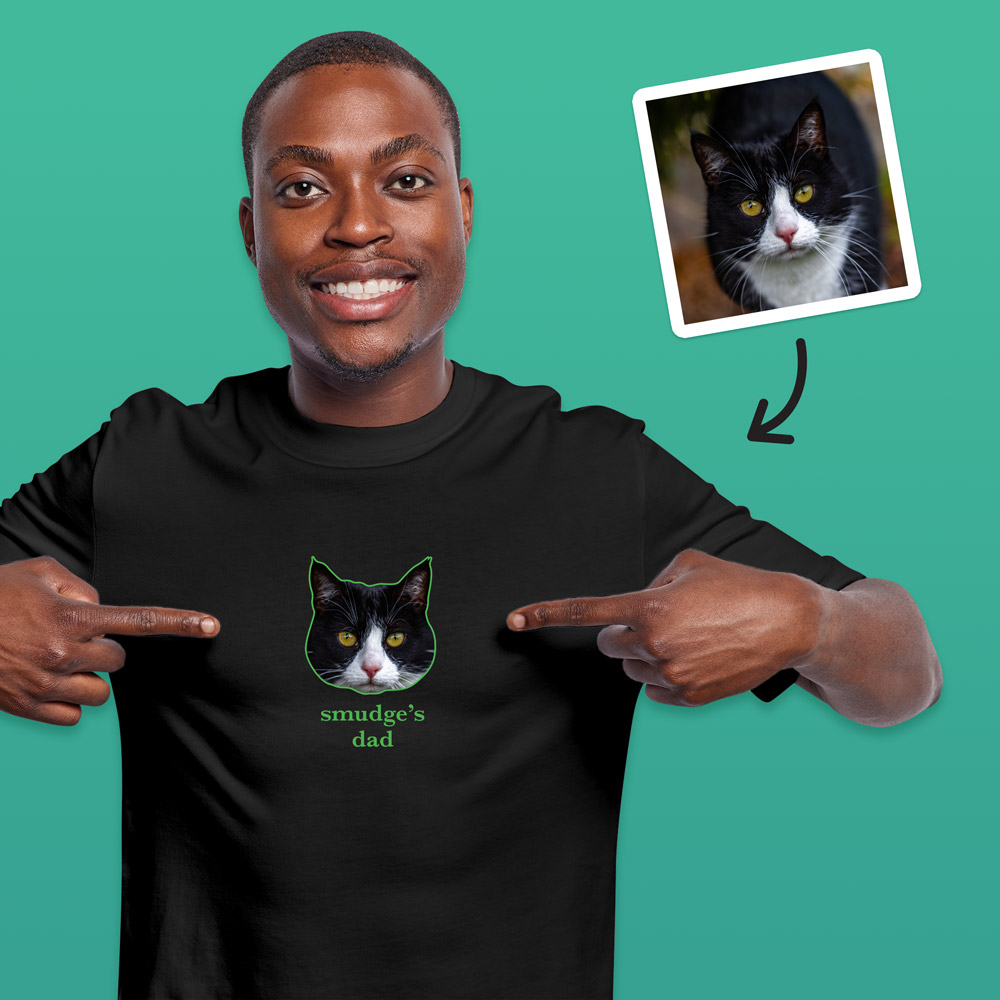 A black t shirt that can be customised with the face of a pet and up to two lines of custom text which has a cat's face on it with the words Smudge's Dad under it