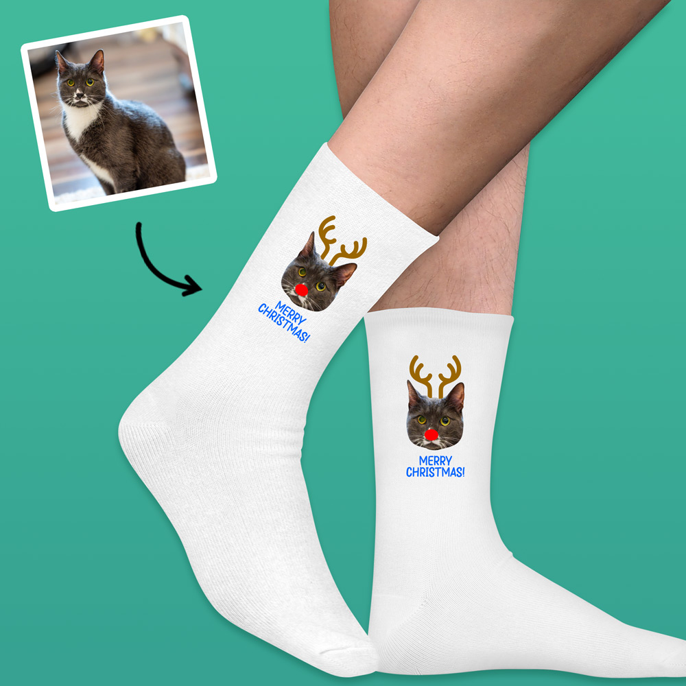 A pair of custom pet socks that has been personalised with a cat's face wearing antlers and a red nose like Rudolph alongside custom text reading Meowy Christmas