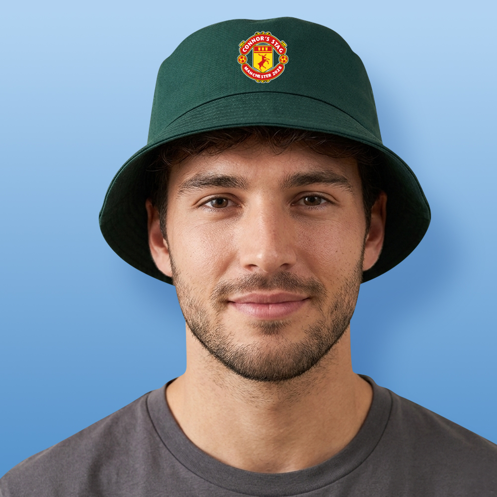 A male model wearing a green Manchester-United inspired custom stag do bucket hat with the Man U logo that is a stag with custom text reading Connor's Stag Manchester 2028
