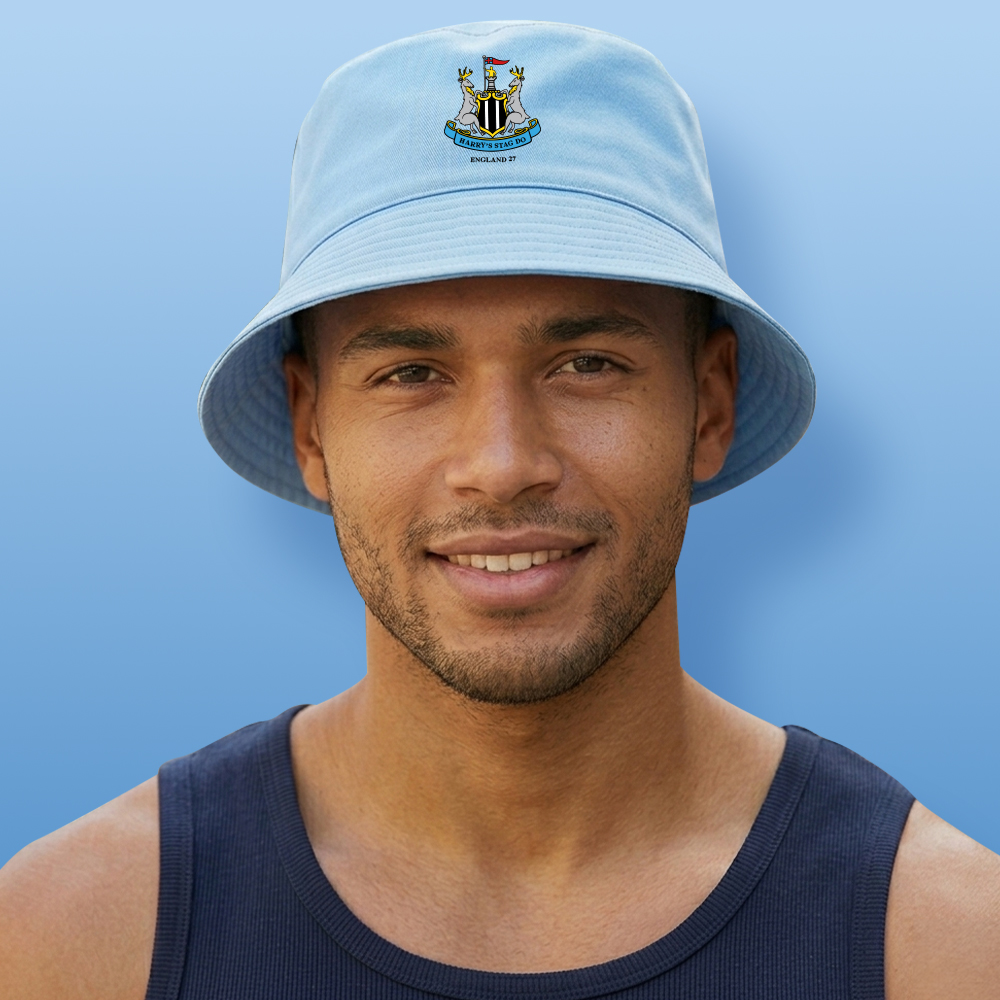 A male model wearing a light blue custom Newcastle United stag-themed bucket hat which has the Newcastle United logo with two stags and custom text reading Harry's Stag England 27