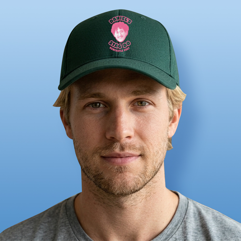 A male model wearing a two tone custom green stag do cap that has been personalised with a pink face photo and custom text reading Daniel's Stag Do Newcastle 2027