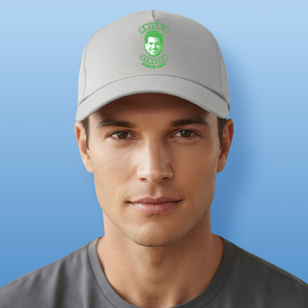 A male model wearing a two tone grey orange stag do cap that has been personalised with a green face photo and custom text reading Amishs' Stag Do Dublin 2028