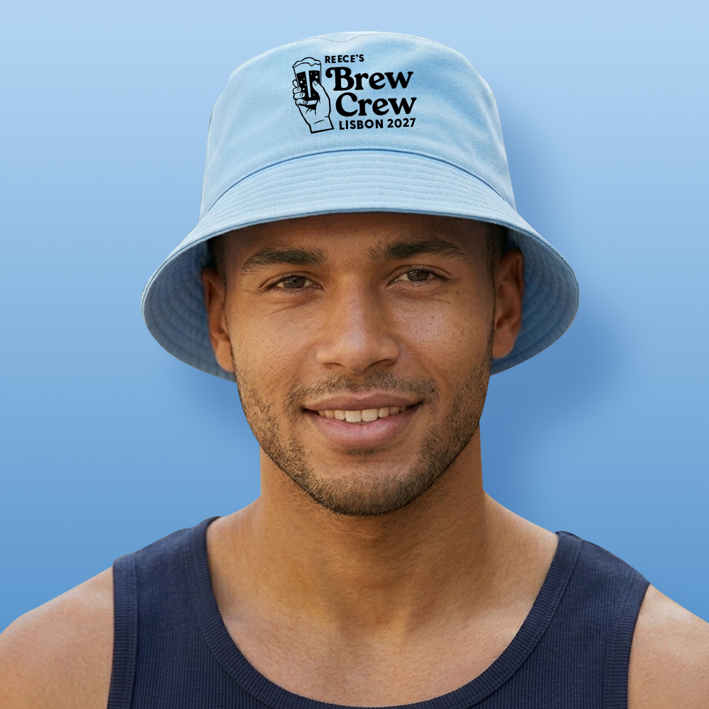 A male model wearing a light blue custom stag do bucket hat with a graphic of a hand holding a beer and custom text reading Reece's Brew Crew Lisbon 2027 in black font