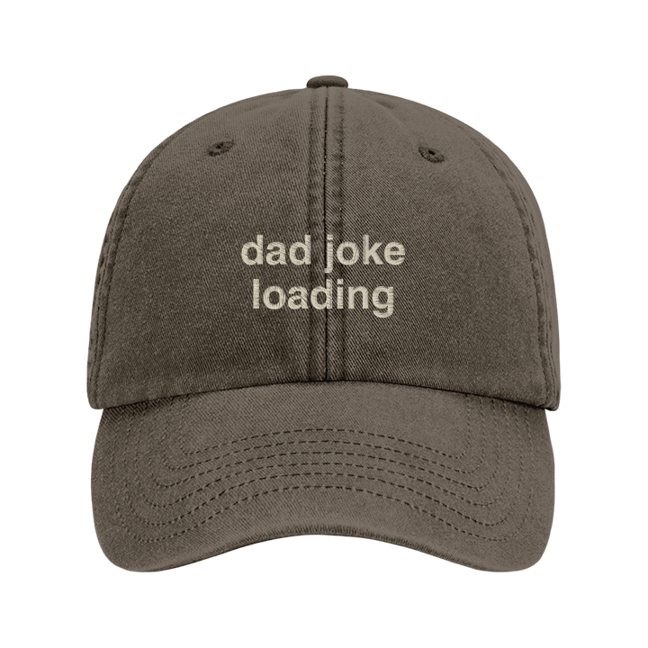 A premium vintage cap in brown with the phrase dad joke loading embroidered in tusk font 