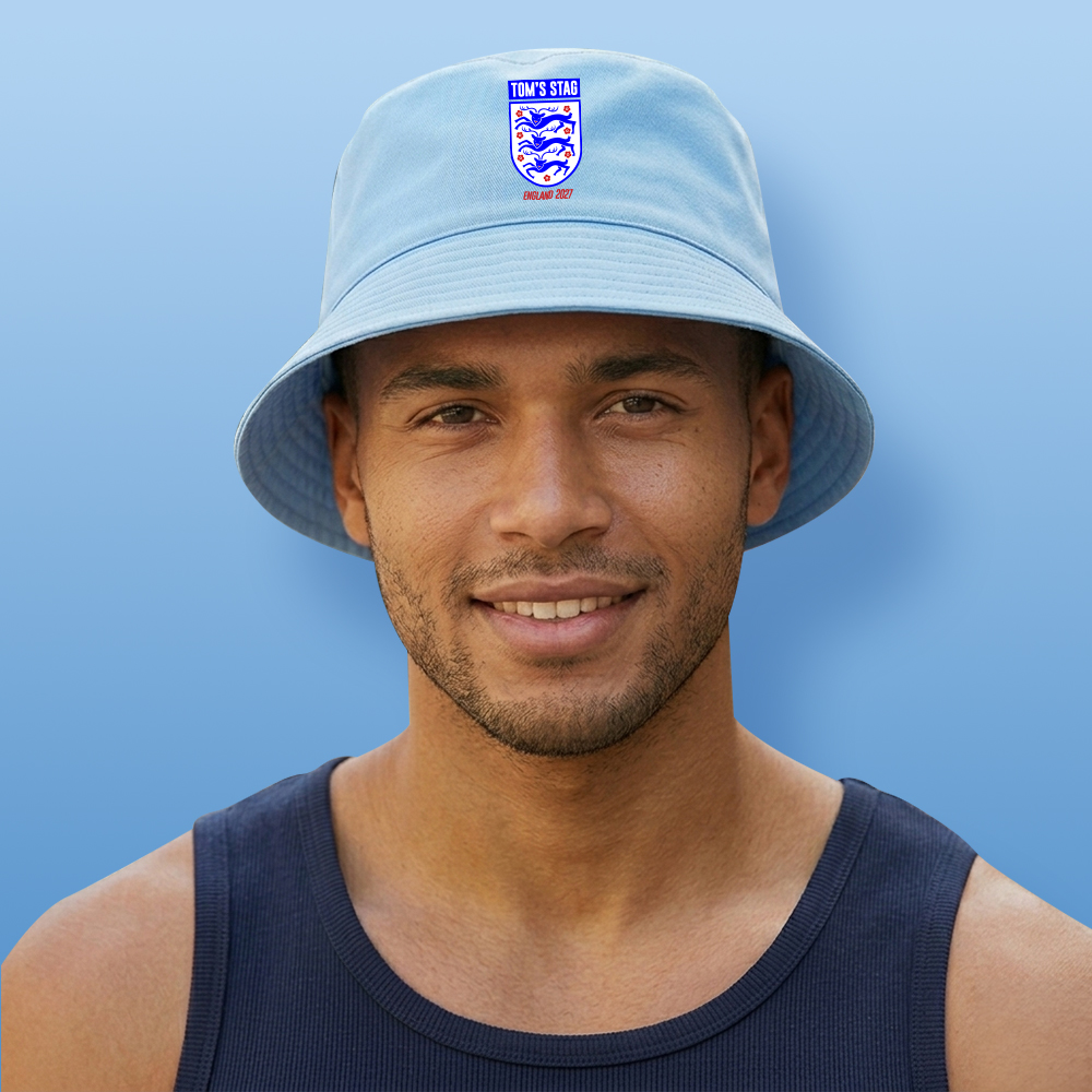 A male model wearing a light blue custom stag do football-themed bucket hat with the England logo and custom text reading Tom's Stag England 2027