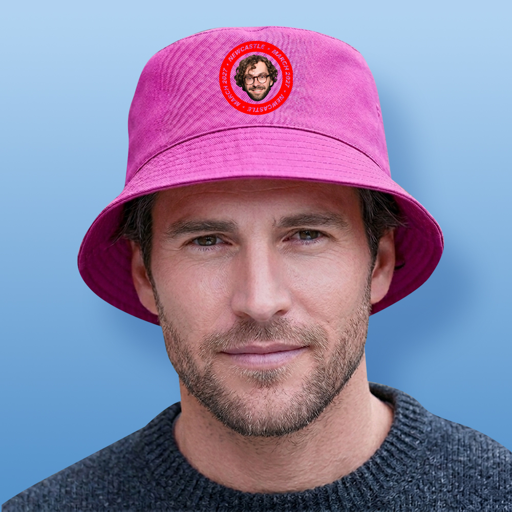 A male model wearing a pink stag do bucket hat that has a circular football badge style design that has been personalised with a photo of a man and the text Newcastle March 2027