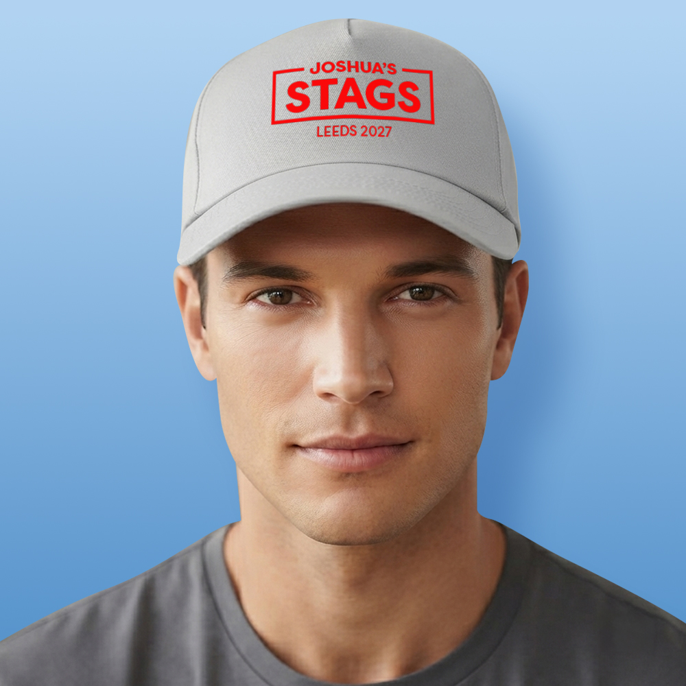 A male model wearing a grey custom stag do cap that reads Joshua's Stags which is in the middle of a rectangular box with Leeds 2027 below it