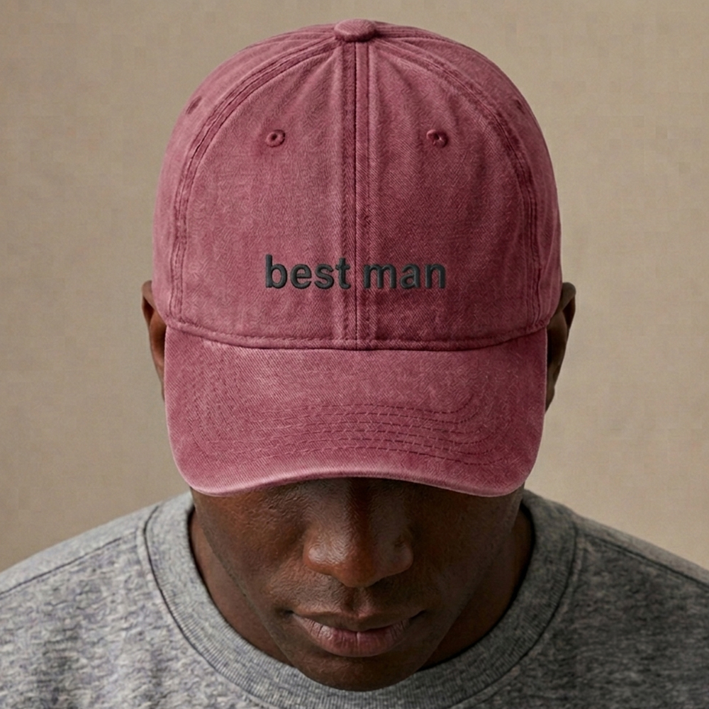 A male model wearing a premium custom stag do cap in red that has been embroidered with best man in pewter text
