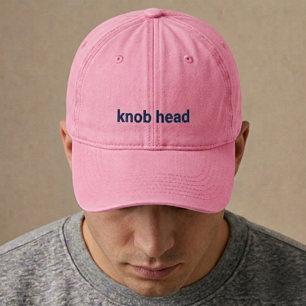 A male model wearing a premium custom stag do cap in pink that has been embroidered with knob head in navy text