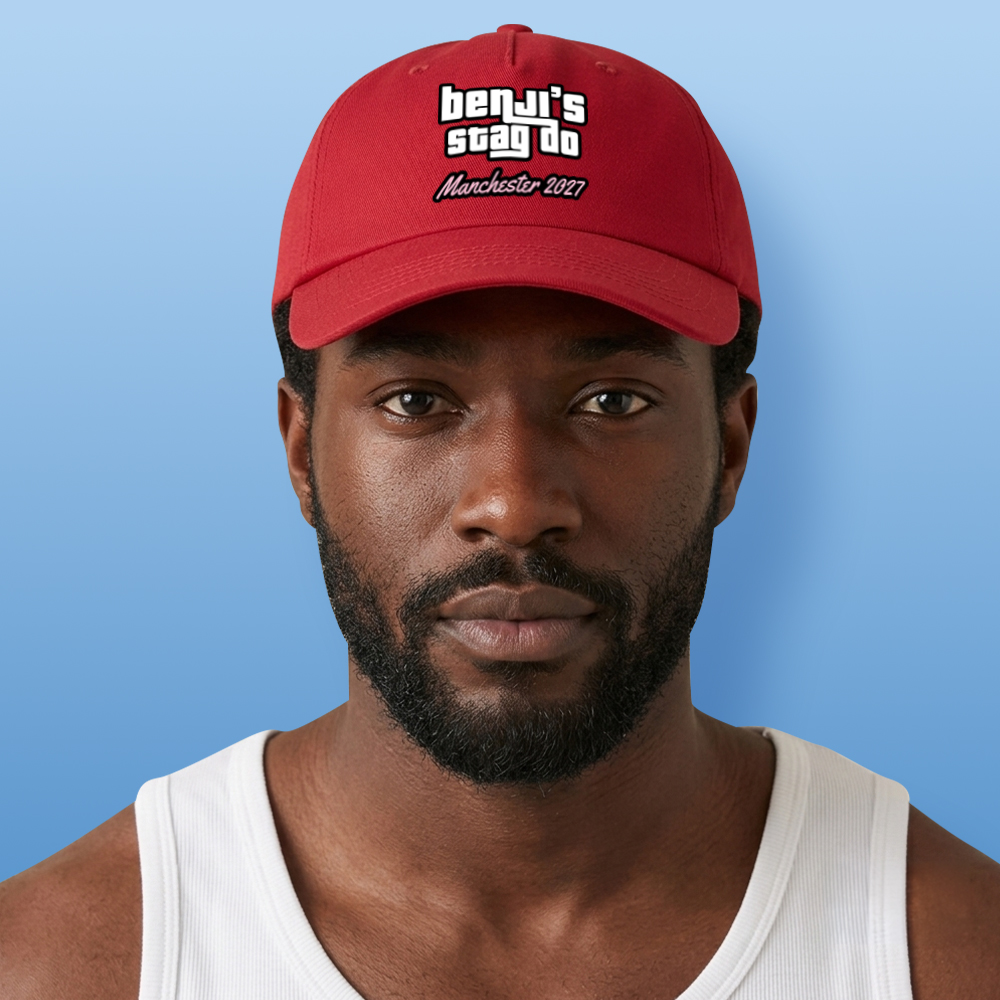 A male model wearing a red custom GTA themed stag do bucket hat that has custom text in the style of the GTA logo reading benji's stag do Manchester 2027