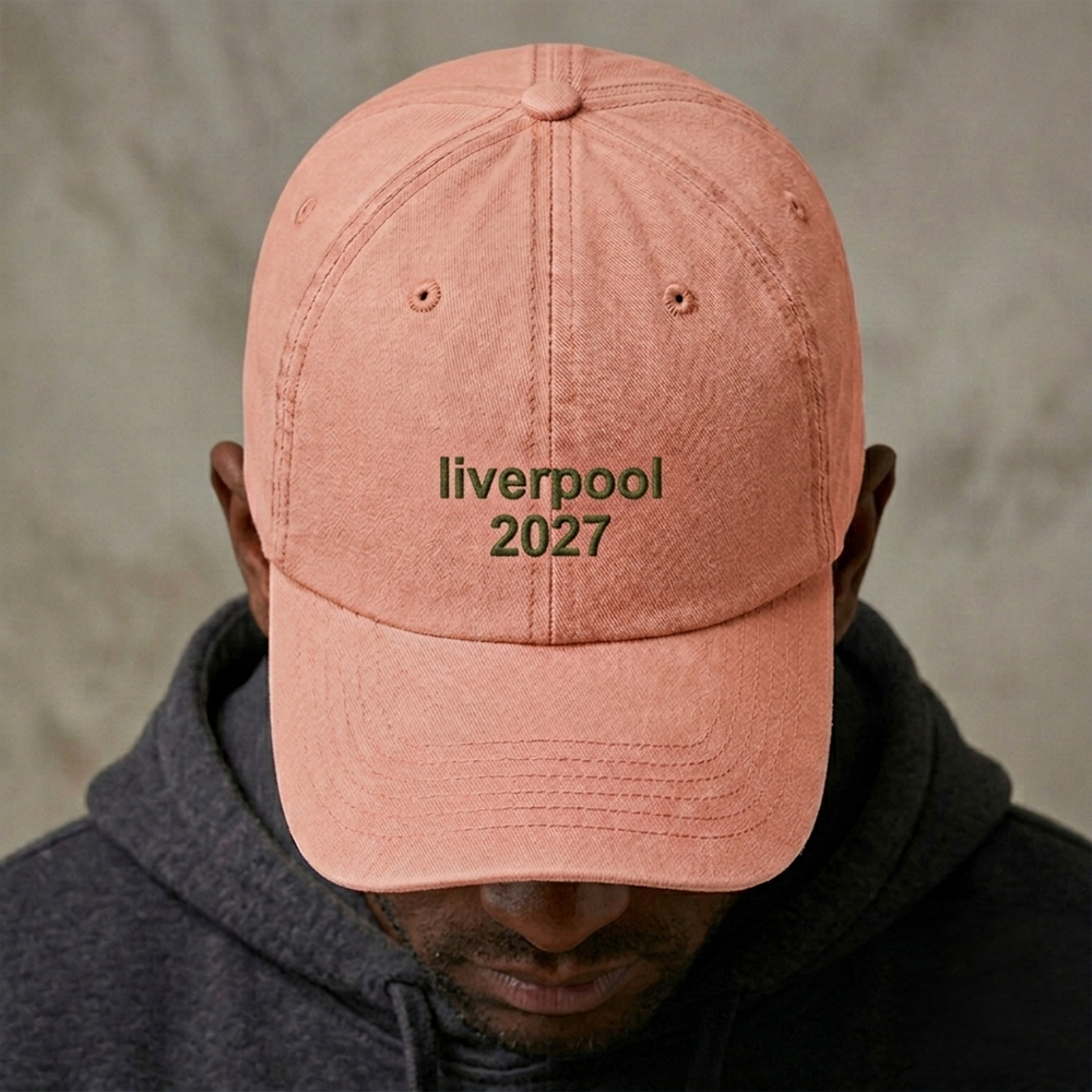 A male model wearing a custom text premium vintage cap in brown that has been embroidered with liverpool 2028