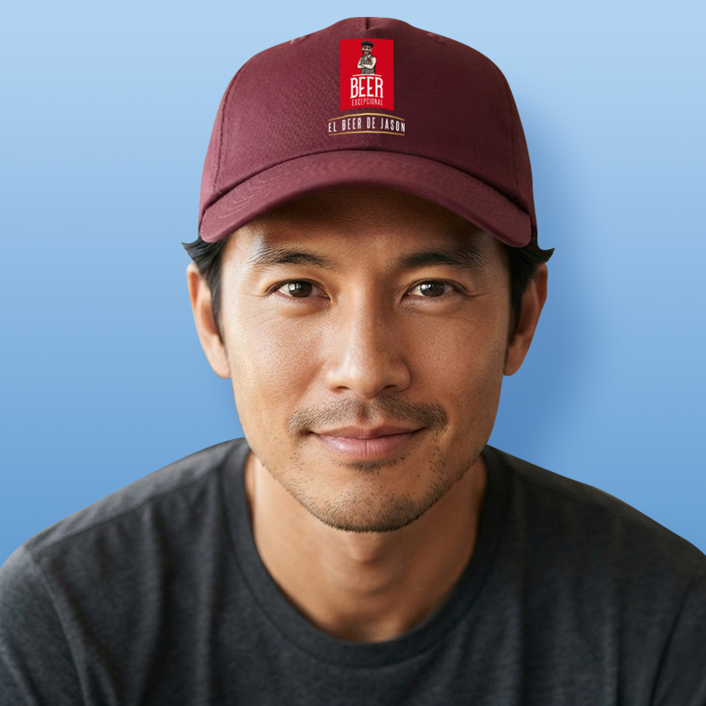 A male model wearing a burgundy custom Madri-themed cap which has been personalised with a photo of a man's face integrated into the Madri man logo with custom text reading El Beer De Jason
