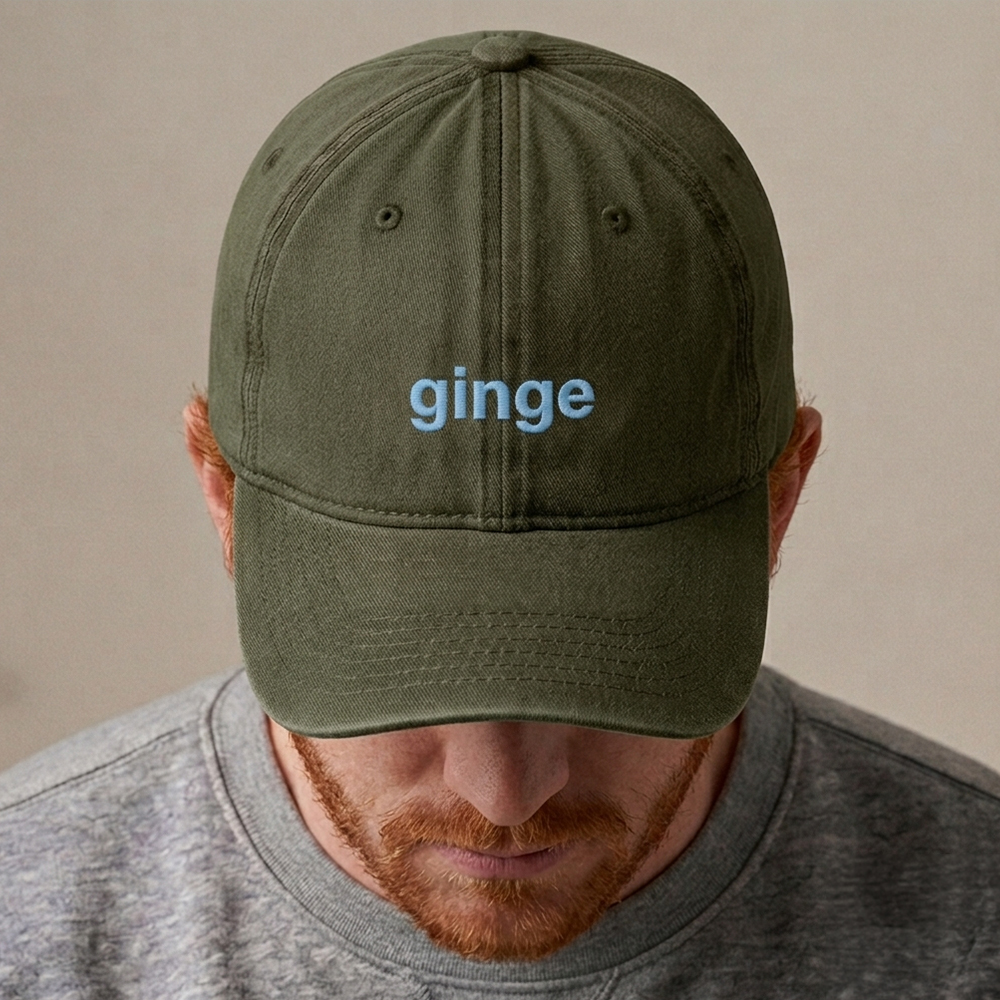 A ginger male model wearing a custom text premium vintage cap in green that has been embroidered with the nickname ginge