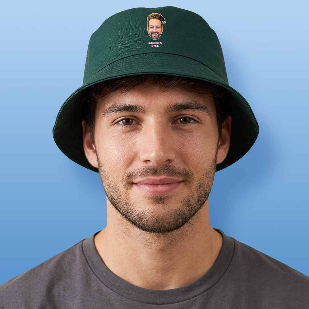A male model wearing a custom green bucket hat that has been personalised with a man's face and custom text reading Damien's Stag