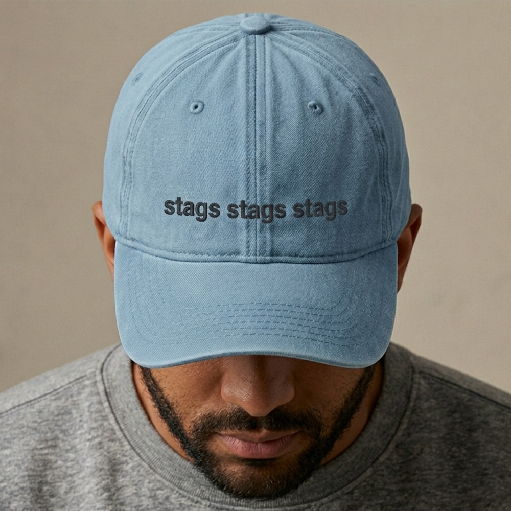 A male model wearing a premium custom stag do cap in light blue that has been embroidered with stags stags stags in black text