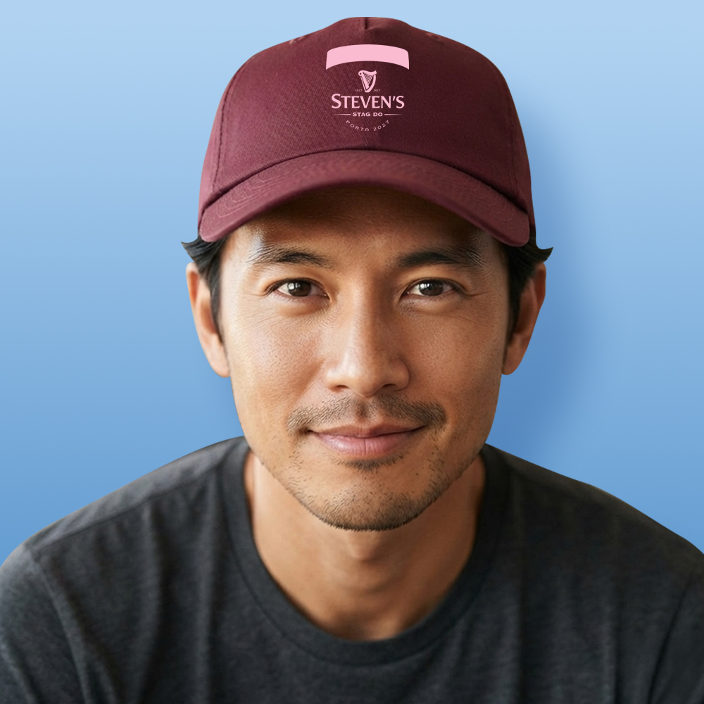 A male model wearing a burgundy custom stag do cap with the Guinness logo reading Ciaran's Stag Do Dublin 2026