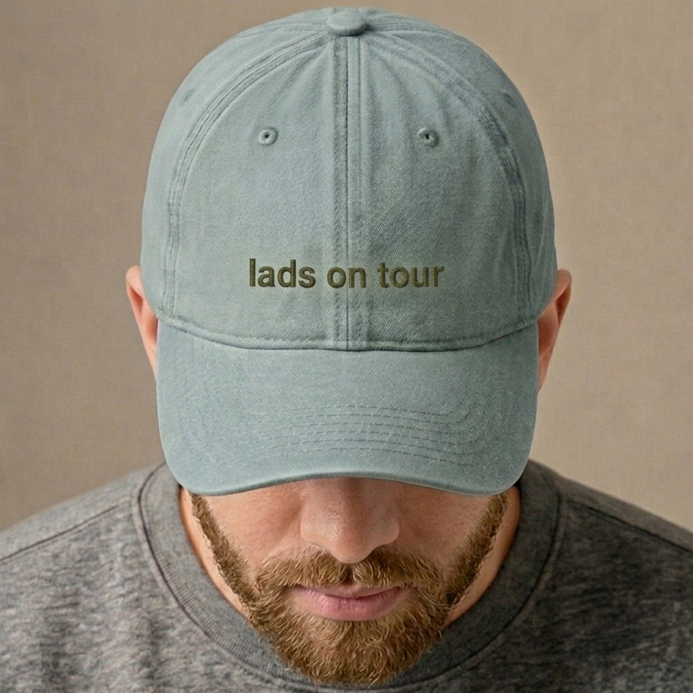 A male model wearing a premium custom stag do cap in green that has been embroidered with the custom text lads on tour