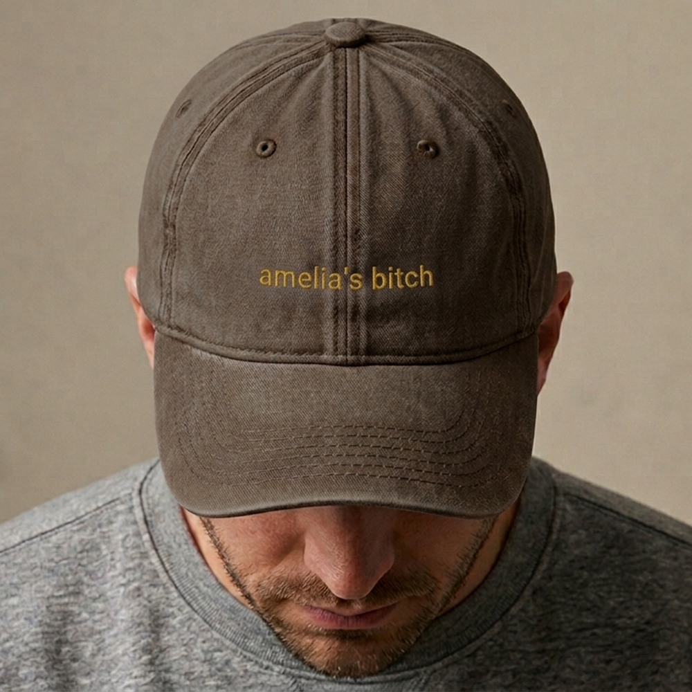 A male model wearing a premium custom stag do cap in green that has been embroidered with the custom text Ameilia's Bitch