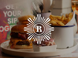 A burger with chips and coleslaw at Revolution