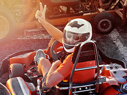 Someone in a go-kart turning around and showing the peace sign