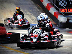 A line of people in go-karts on a track, racing