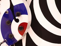 Image of a circle pattered object with four dials on with numbers 