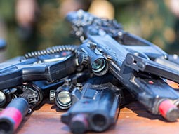 A group of guns placed on top of each other on a table