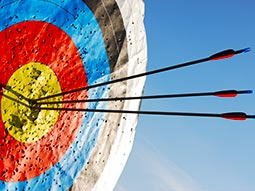 A close up of an archery target with three arrows sticking out of it