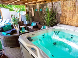 An outdoor space with a hot tub in the foreground
