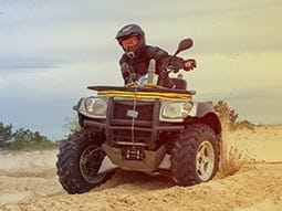 Image of a guy on a quad bike on the sand