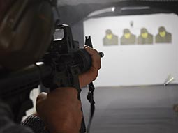 A close up of a man aiming a gun at targets