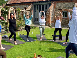 A group of women holding a yoga pose outdoors