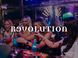 A group of girls clinking their cocktails at Revolution