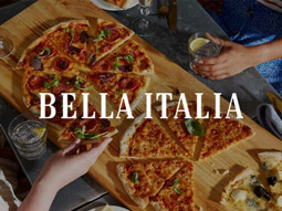 Three pizzas on a wooden plank with the Bella Italia logo overlayed