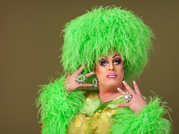 Drag queen, in big green wig and fluffy green outfit, as a part of afternoon drag show in Liverpool