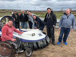A group of men next to a hovercraft