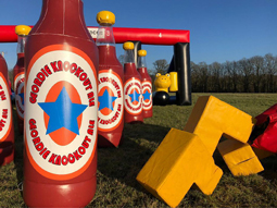It's a Geordie Knockout in Newcastle, big brown bottles in the foreground and inflatable obstacles in the background