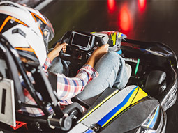 Two people racing on an outdoor track in helmets and overalls