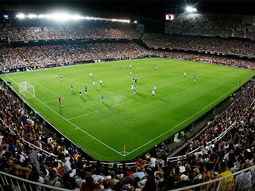 The Mestalla Stadium in Valencia with people in the crowd and people playing on the pitch