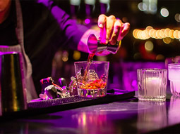 A barman pouring a shot of alcohol into a drink at a nightclub in Valencia