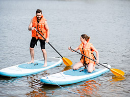 Two people learning how to paddle board on a cloudy day with Stag Hen Spain in Valencia