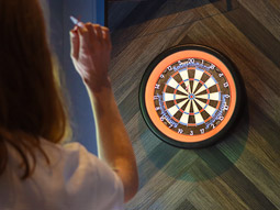 A customer throws a dart at a dartboard at Tops Dart Club in Liverpool.