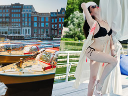 A womans torso with denim shorts on and a sparkly bra on a canal strip boat in Amsterdam